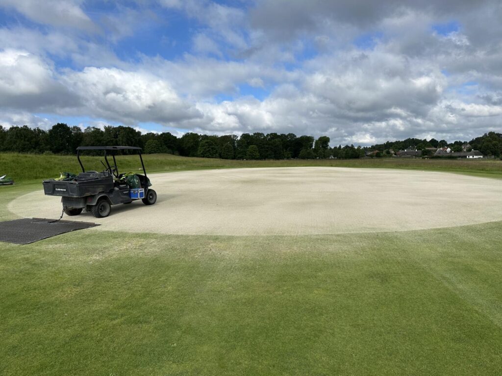 Prikket green med udjævningen af hvidt sand.